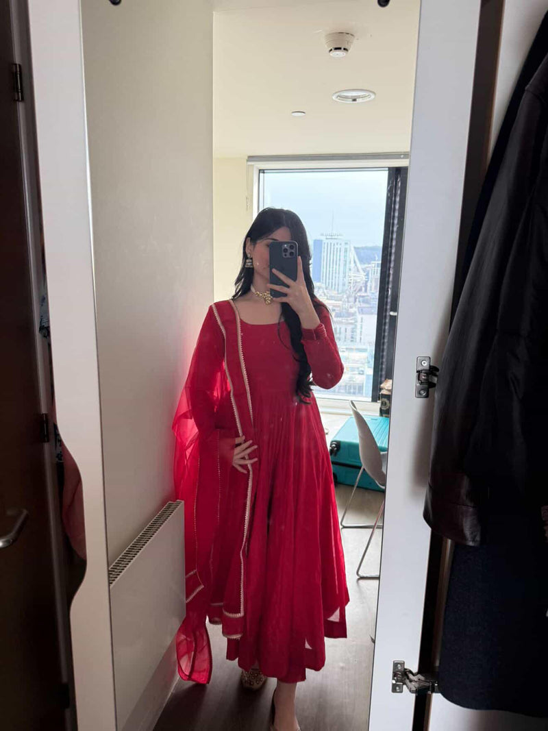 Red Anarkali suit set by Indian Virasat featuring intricate embroidery and flowing fabric, ideal for traditional occasions.